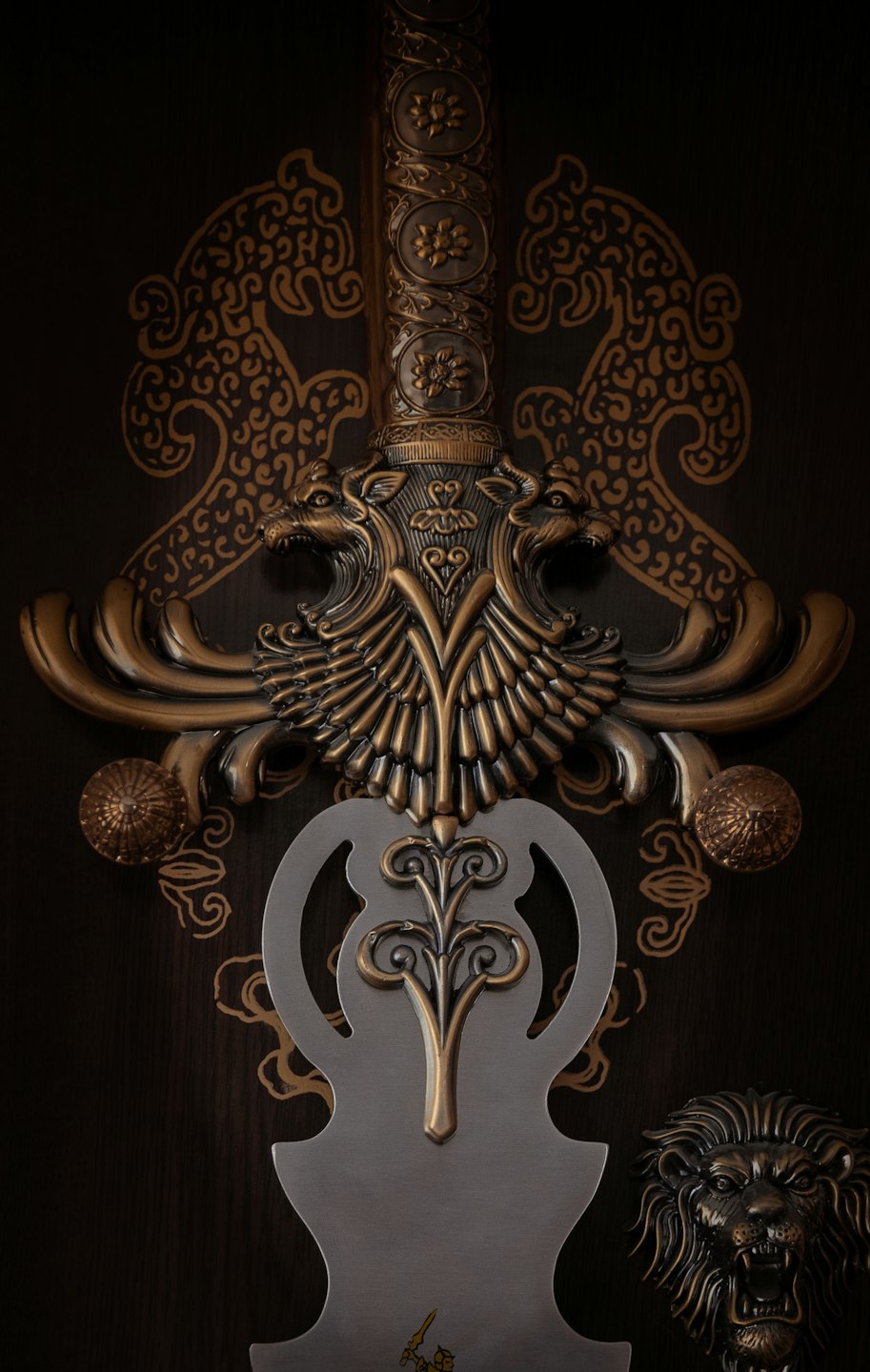 Ornate sword with a golden hilt and a bronze lion sculpture.