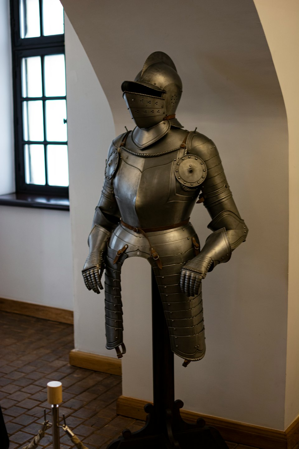 Medieval metal plate armor stands on a display rack.